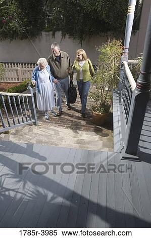 Mature couple walking with senior woman towards front of house View Large Photo Image Stock Photography - Mature couple walking with senior woman towards front of house. Fotosearch