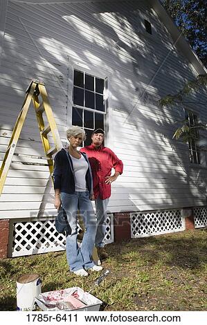 Mature couple with ladder and painting tools standing outside house View Large Photo Image Stock Image - Mature couple with ladder and painting tools standing outside house. Fotosearch
