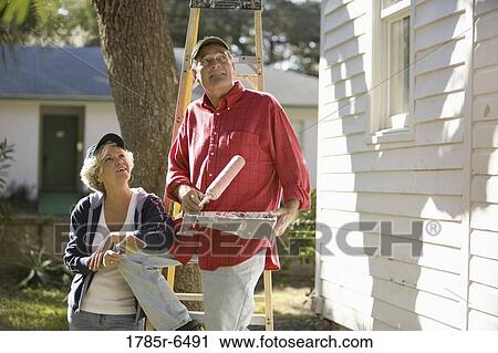 Mature couple with ladder and painting tools preparing to paint outside of house View Large Photo Image Stock Image - Mature couple with ladder and painting tools preparing to paint outside of house. Fotosearch