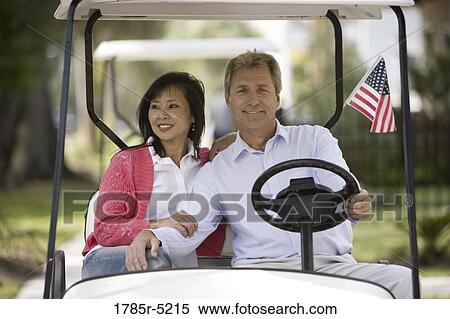 Mature inter-racial couple driving their golfcart through their neighborhood View Large Photo Image Stock Photography - Mature inter-racial couple driving their golfcart through their neighborhood. Fotosearch