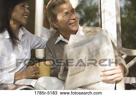 Mature inter-racial couple holding coffee mug and newspaper View Large Photo Image Stock Image - Mature inter-racial couple holding coffee mug and newspaper. Fotosearch