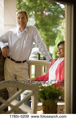 Mature inter-racial couple on front porch of their hosue View Large Photo Image Stock Photo - Mature inter-racial couple on front porch of their hosue. Fotosearch
