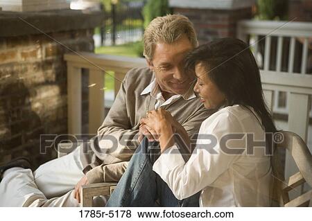Mature interracial couple sitting on front porch View Large Photo Image Stock Photo - Mature interracial couple sitting on front porch. Fotosearch