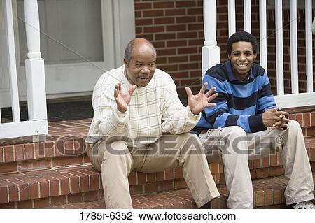 Mature man and adult son sitting on front porch of house View Large Photo Image Stock Image - Mature man and adult son sitting on front porch of house. Fotosearch