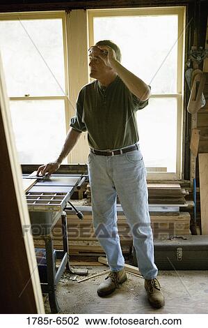 Mature man in tool shed surrounded by lumber and carpentry tools View Large Photo Image Stock Image - Mature man in tool shed surrounded by lumber and carpentry tools. Fotosearch