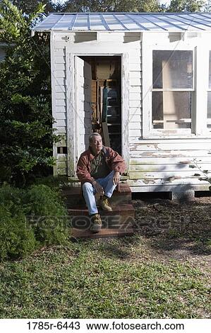 Mature man sitting on doorstep of dilapidated tool shed View Large Photo Image Stock Image - Mature man sitting on doorstep of dilapidated tool shed. Fotosearch