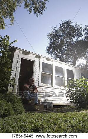 Mature man sitting on doorstep of dilapidated tool shed View Large Photo Image Stock Photography - Mature man sitting on doorstep of dilapidated tool shed. Fotosearch