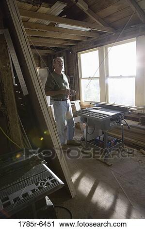 Mature man working with lumber and carpentry tools in tool shed View Large Photo Image Stock Image - Mature man working with lumber and carpentry tools in tool shed. Fotosearch