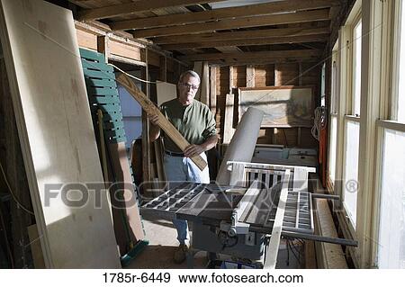 Mature man working with lumber and carpentry tools in tool shed View Large Photo Image Stock Photo - Mature man working with lumber and carpentry tools in tool shed. Fotosearch