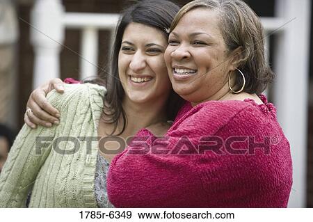 Stock Photo - Mature woman embracing younger woman. Fotosearch