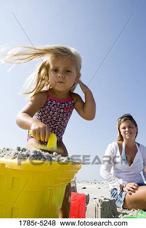 Mother and daughter building sandcastles on the beach View Large Photo Image Stock Photo - Mother and daughter building sandcastles on the beach. Fotosearch
