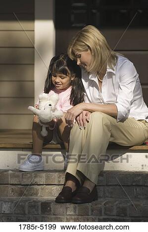 Mother and daughter sitting on front steps of house View Large Photo Image Stock Photo - Mother and daughter sitting on front steps of house. Fotosearch