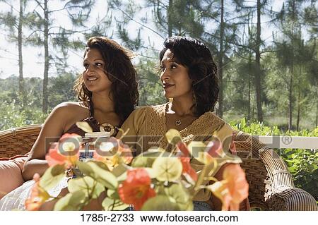 Mother and daughter sitting side by side on a chair View Large Photo Image Stock Image - Mother and daughter sitting side by side on a chair. Fotosearch