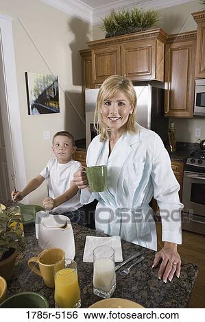 Mother having coffee while son waits for breakfast in the kitchen View Large Photo Image Stock Photograph - Mother having coffee while son waits for breakfast in the kitchen. Fotosearch