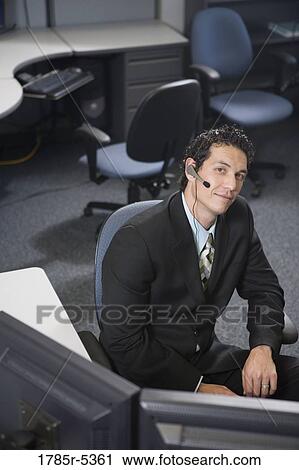 Office worker in a suit with headset sitting at his desk View Large Photo Image Stock Image - Office worker in a suit with headset sitting at his desk. Fotosearch