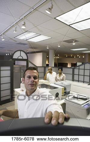 Office worker looking over cubicle wall near office equipment View Large Photo Image Stock Photo - Office worker looking over cubicle wall near office equipment. Fotosearch