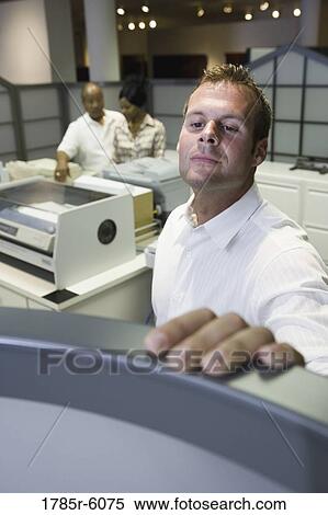 Office worker looking over cubicle wall near office equipment View Large Photo Image Stock Photography - Office worker looking over cubicle wall near office equipment. Fotosearch