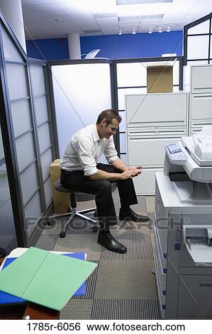 Office worker sitting alone by the copy machine View Large Photo Image Stock Photograph - Office worker sitting alone by the copy machine. Fotosearch
