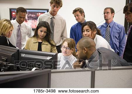 Stock Photo - Office workers gathered around computer screen. Fotosearch
