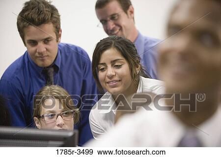 Office workers gathered around computer screen View Large Photo Image Stock Photo - Office workers gathered around computer screen. Fotosearch