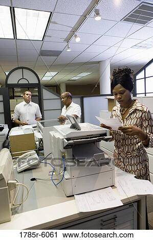 Office workers using office equipment View Large Photo Image Stock Image - Office workers using office equipment. Fotosearch