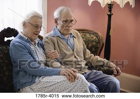 Pensive senior couple sitting on sofa View Large Photo Image Stock Photography - Pensive senior couple sitting on sofa. Fotosearch