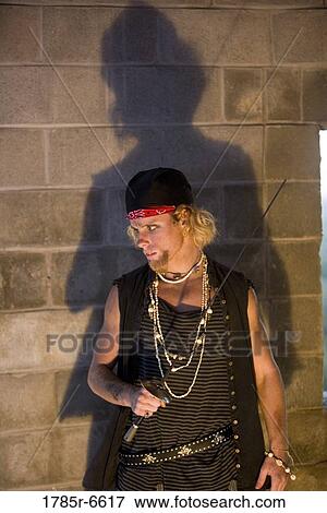 Pirate brandishing a sword against a castle wall View Large Photo Image Stock Photo - Pirate brandishing a sword against a castle wall. Fotosearch