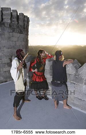 Pirates armed with a pistol and a sword looking over a castle parapet View Large Photo Image Stock Photography - Pirates armed with a pistol and a sword looking over a castle parapet. Fotosearch