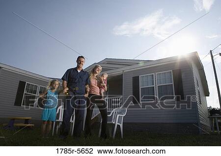 Portrait of a blue-collar family standing in front of a trailer home View Large Photo Image Stock Image - Portrait of a blue-collar family standing in front of a trailer home. Fotosearch