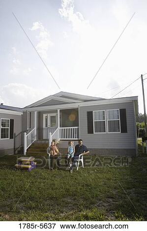 Portrait of a blue-collar family sitting in front of a trailer home View Large Photo Image Stock Photo - Portrait of a blue-collar family sitting in front of a trailer home. Fotosearch