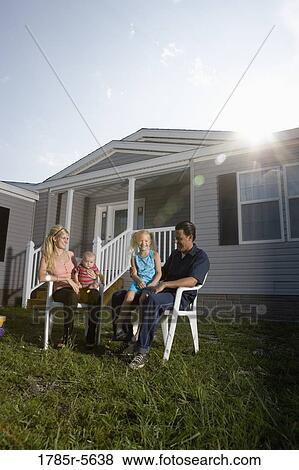 Portrait of a blue-collar family sitting in front of a trailer home View Large Photo Image Stock Photo - Portrait of a blue-collar family sitting in front of a trailer home. Fotosearch