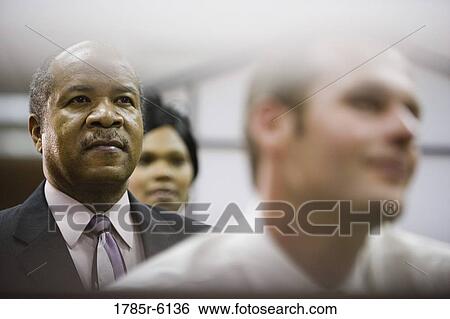 Portrait of a contemplative mature businessman with colleagues View Large Photo Image Stock Photograph - Portrait of a contemplative mature businessman with colleagues. Fotosearch