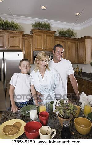 Portrait of a couple with their son having breakfast in the kitchen View Large Photo Image Stock Photo - Portrait of a couple with their son having breakfast in the kitchen. Fotosearch