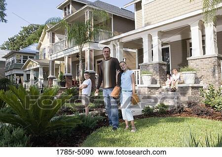 Stock Image - Portrait of a family in front of their house. Fotosearch