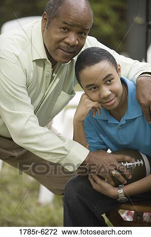 Portrait of a father and son holding a football View Large Photo Image Stock Image - Portrait of a father and son holding a football. Fotosearch