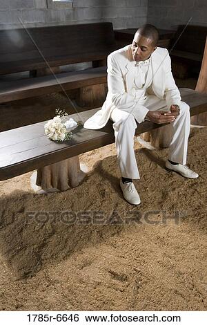Portrait of a groom sitting alone on a wooden bench next to bouquet of roses View Large Photo Image Stock Photograph - Portrait of a groom sitting alone on a wooden bench next to bouquet of roses. Fotosearch
