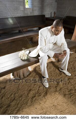 Portrait of a groom sitting alone on a wooden bench next to bouquet of roses View Large Photo Image Stock Photography - Portrait of a groom sitting alone on a wooden bench next to bouquet of roses. Fotosearch
