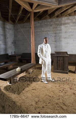 Stock Photo - Portrait of a groom standing next to bouquet of roses resting on bench. Fotosearch