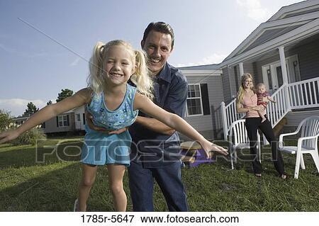 Portrait of a man playing with his blue-collar family in front of a trailer home View Large Photo Image Stock Photo - Portrait of a man playing with his blue-collar family in front of a trailer home. Fotosearch