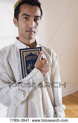 Portrait of a Muslim man holding Koran View Large Photo Image Stock Image - Portrait of a Muslim man holding Koran. Fotosearch