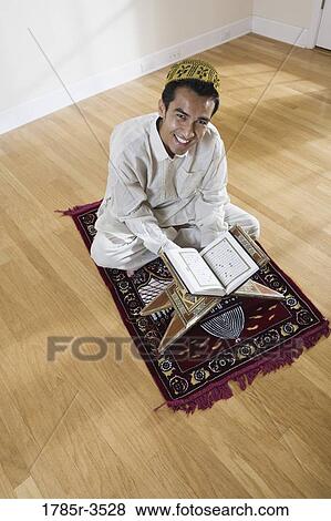 Stock Photo - Portrait of a Muslim man sitting on a prayer mat. Fotosearch