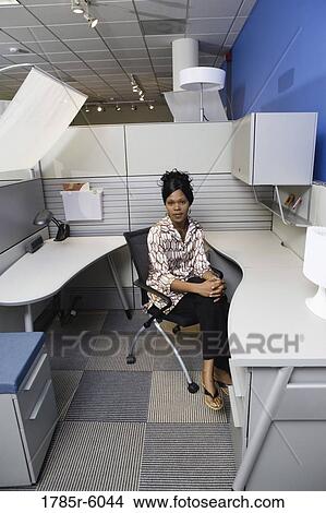 Portrait of a pensive young woman sitting in a new office cubicle View Large Photo Image Picture - Portrait of a pensive young woman sitting in a new office cubicle. Fotosearch