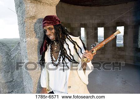 Portrait of a pirate armed with a gun leaning against a castle wall View Large Photo Image Stock Image - Portrait of a pirate armed with a gun leaning against a castle wall. Fotosearch
