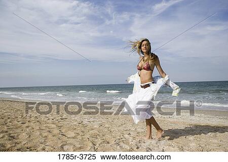 Portrait of a scantily clad young woman standing on a beach View Large Photo Image Stock Photography - Portrait of a scantily clad young woman standing on a beach. Fotosearch