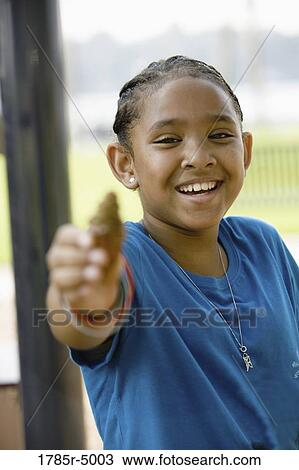Portrait of a smiling girl holding up a pine cone View Large Photo Image Stock Image - Portrait of a smiling girl holding up a pine cone. Fotosearch