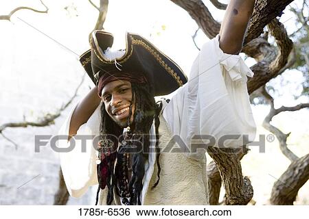 Portrait of a smiling pirate standing by a tree View Large Photo Image Stock Photograph - Portrait of a smiling pirate standing by a tree. Fotosearch