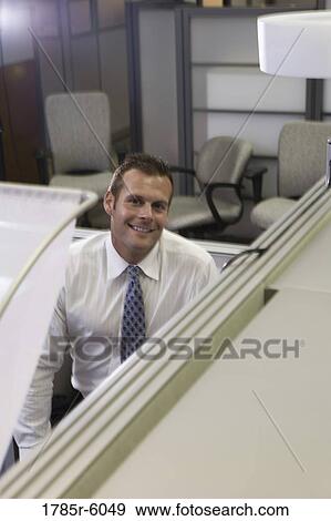 Portrait of a smiling young man looking over his cubicle wall View Large Photo Image Stock Photo - Portrait of a smiling young man looking over his cubicle wall. Fotosearch