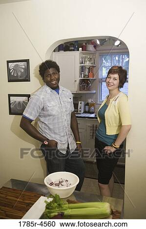 Portrait of a smiling young inter-racial couple outside their kitchen View Large Photo Image Stock Image - Portrait of a smiling young inter-racial couple outside their kitchen. Fotosearch