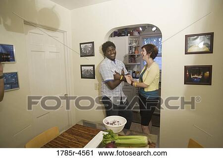 Portrait of a smiling young inter-racial couple outside their kitchen View Large Photo Image Stock Image - Portrait of a smiling young inter-racial couple outside their kitchen. Fotosearch
