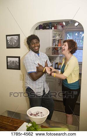 Portrait of a smiling young inter-racial couple outside their kitchen View Large Photo Image Stock Image - Portrait of a smiling young inter-racial couple outside their kitchen. Fotosearch